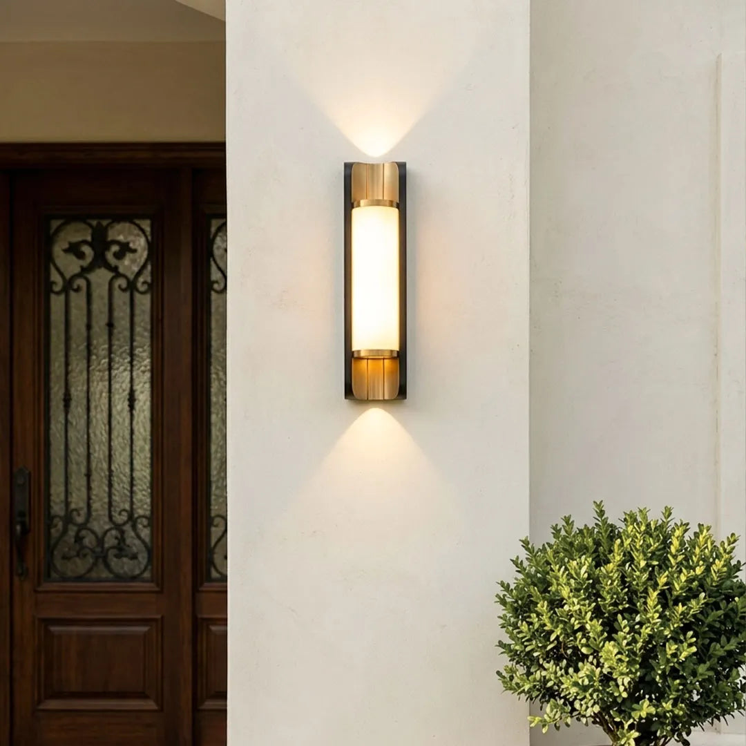 Modern up down outdoor wall sconce illuminating a luxury patio with warm ambient lighting.