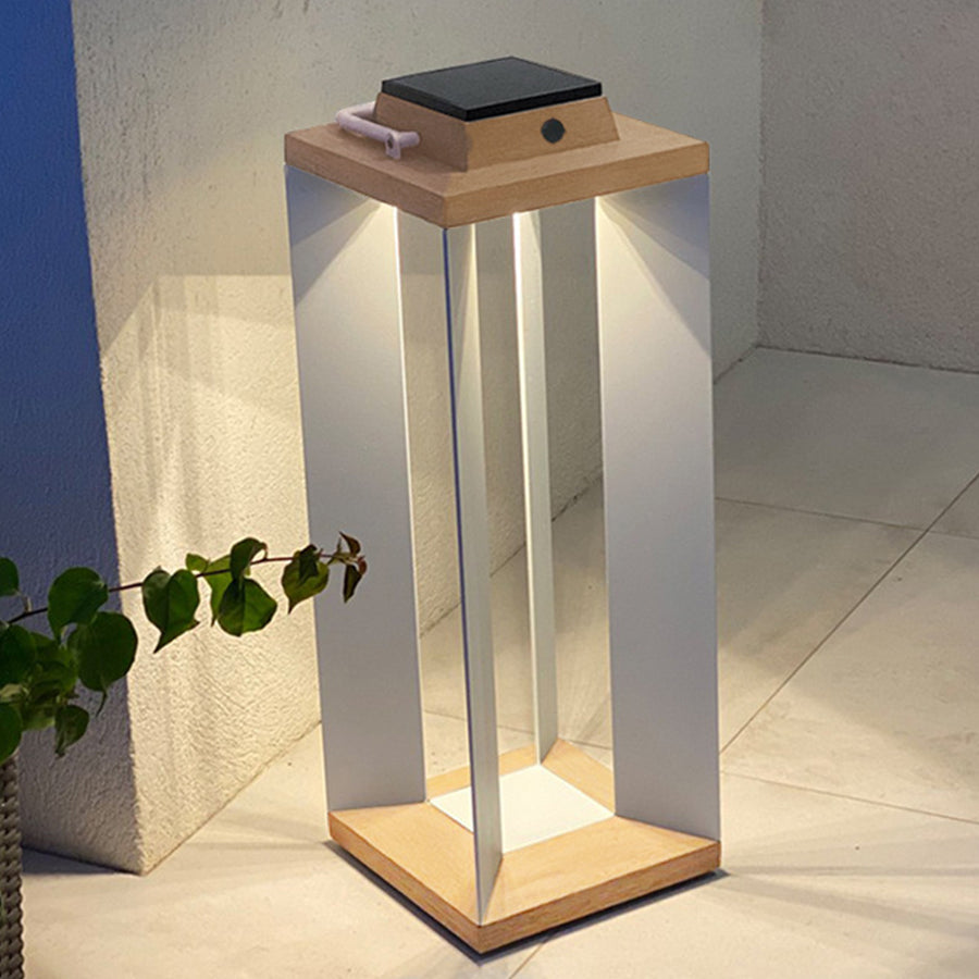 Pair of glowing wooden solar lanterns providing warm atmospheric lighting on outdoor patio