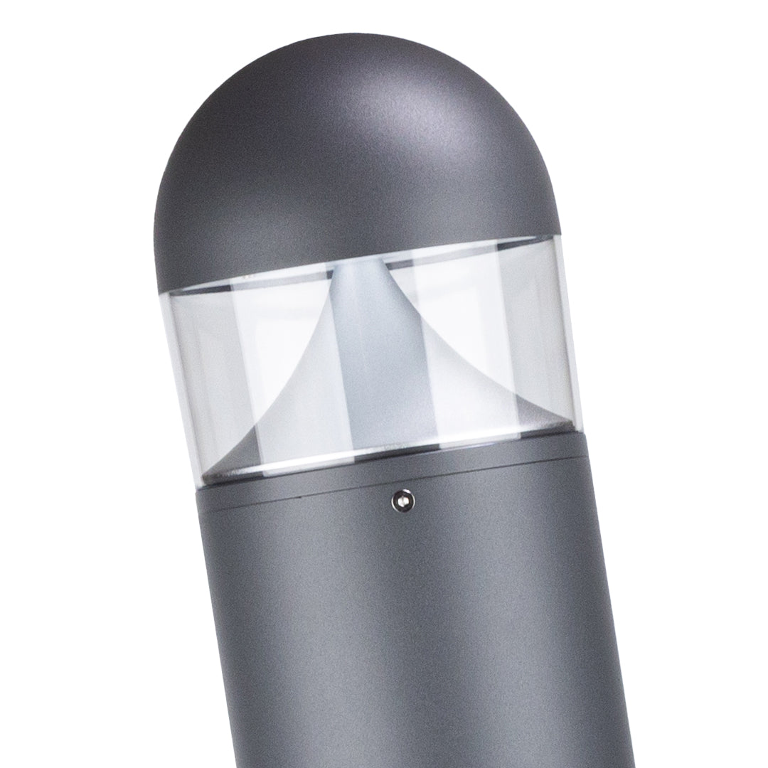 Bollard light casting directional illumination along paved path with light trails