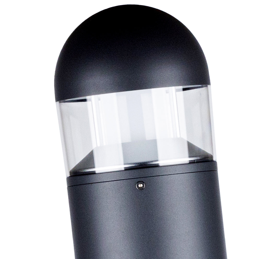 Bollard light casting warm directional glow along paved pathway surface