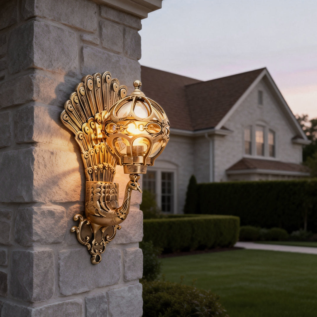 Outdoor peacock wall light installed on pillar beside residential entrance.