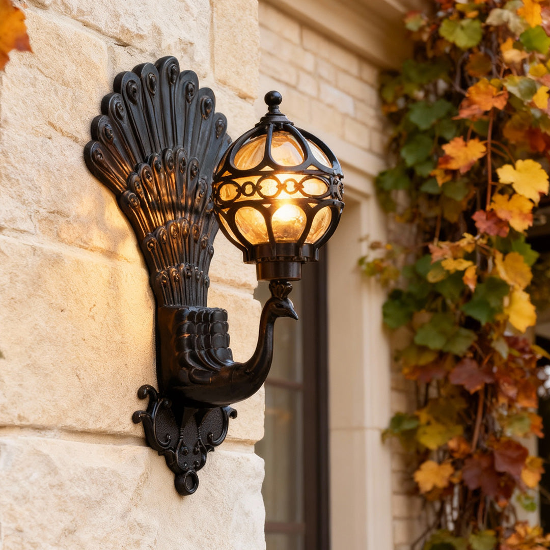 Peacock wall light mounted on exterior stone wall with warm vintage glow.