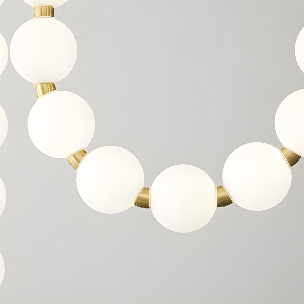 Pearl necklace light fixture with a golden chain, providing soft illumination.