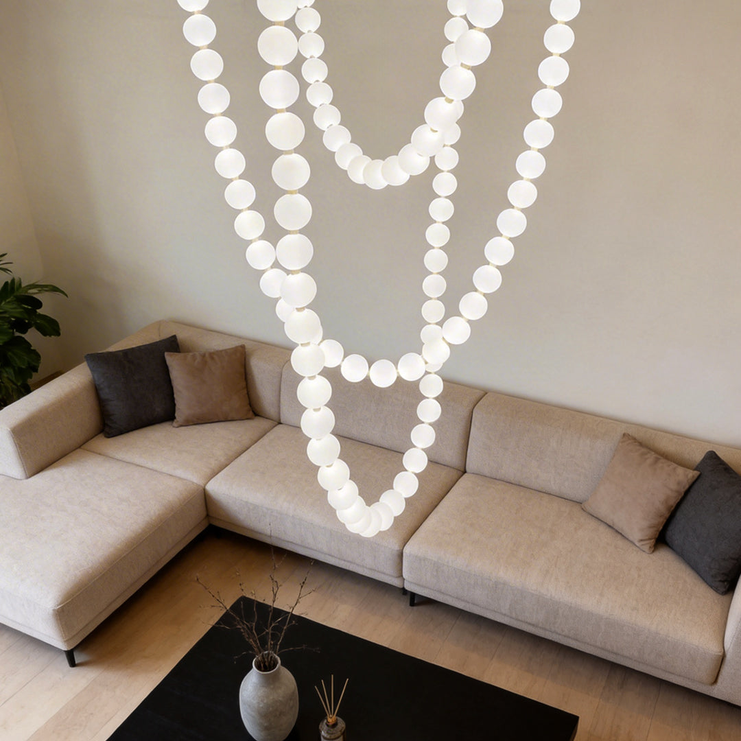 Pearl necklace light fixture with a minimalist design, illuminating a cozy living room.