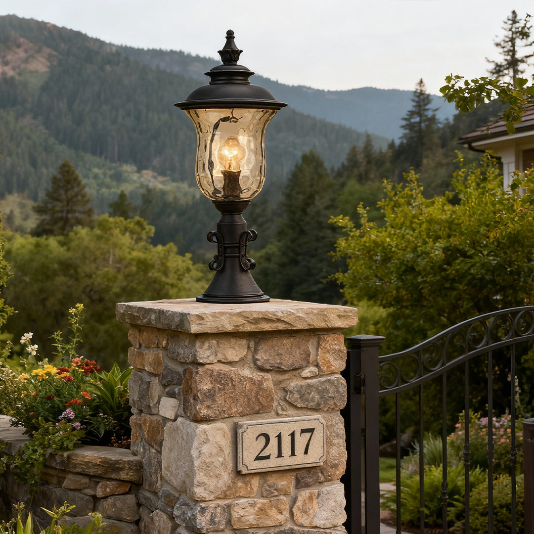 Pillar gate light illuminating stone entrance post with address number and mountain backdrop