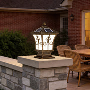 Pillar lantern lights with a vintage design, installed on a stone pillar near a modern house.