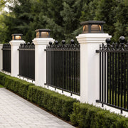 Elegant pillar light design outdoor installed along a black metal fence with white stone pillars.