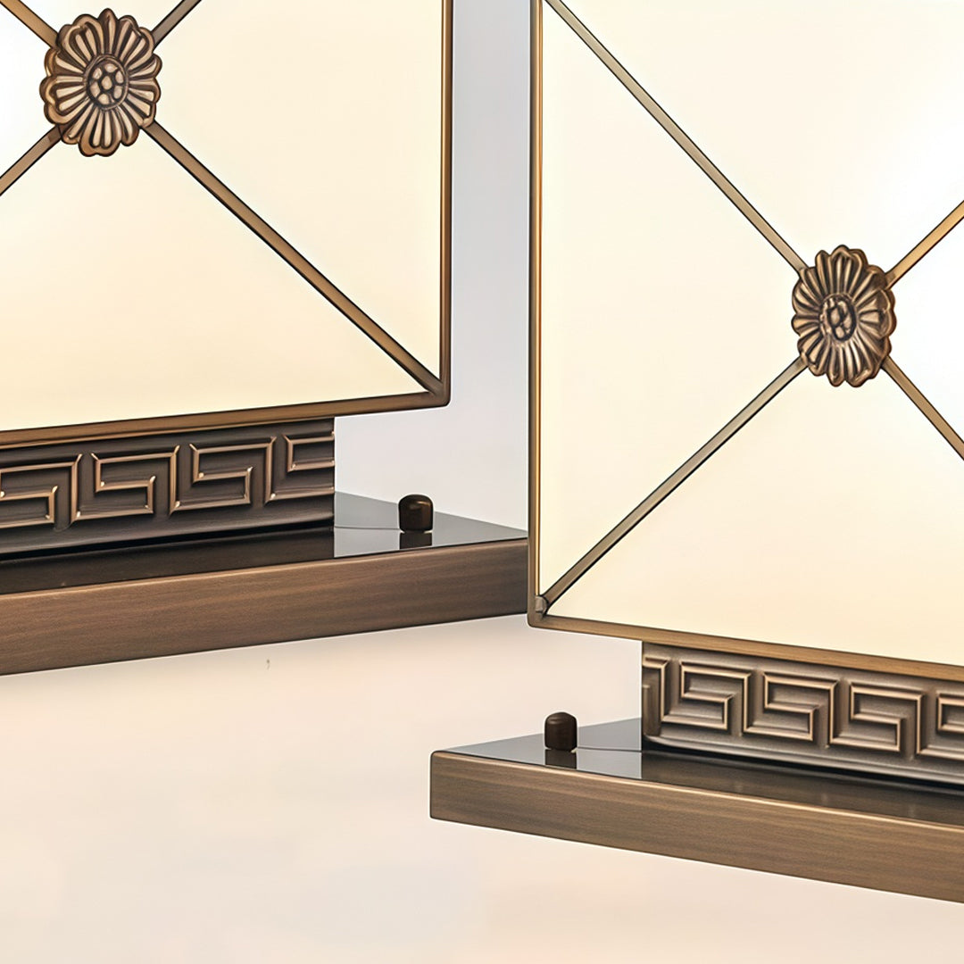 Close-up of decorative pillar light solar with geometric gold frame and frosted glass panels.