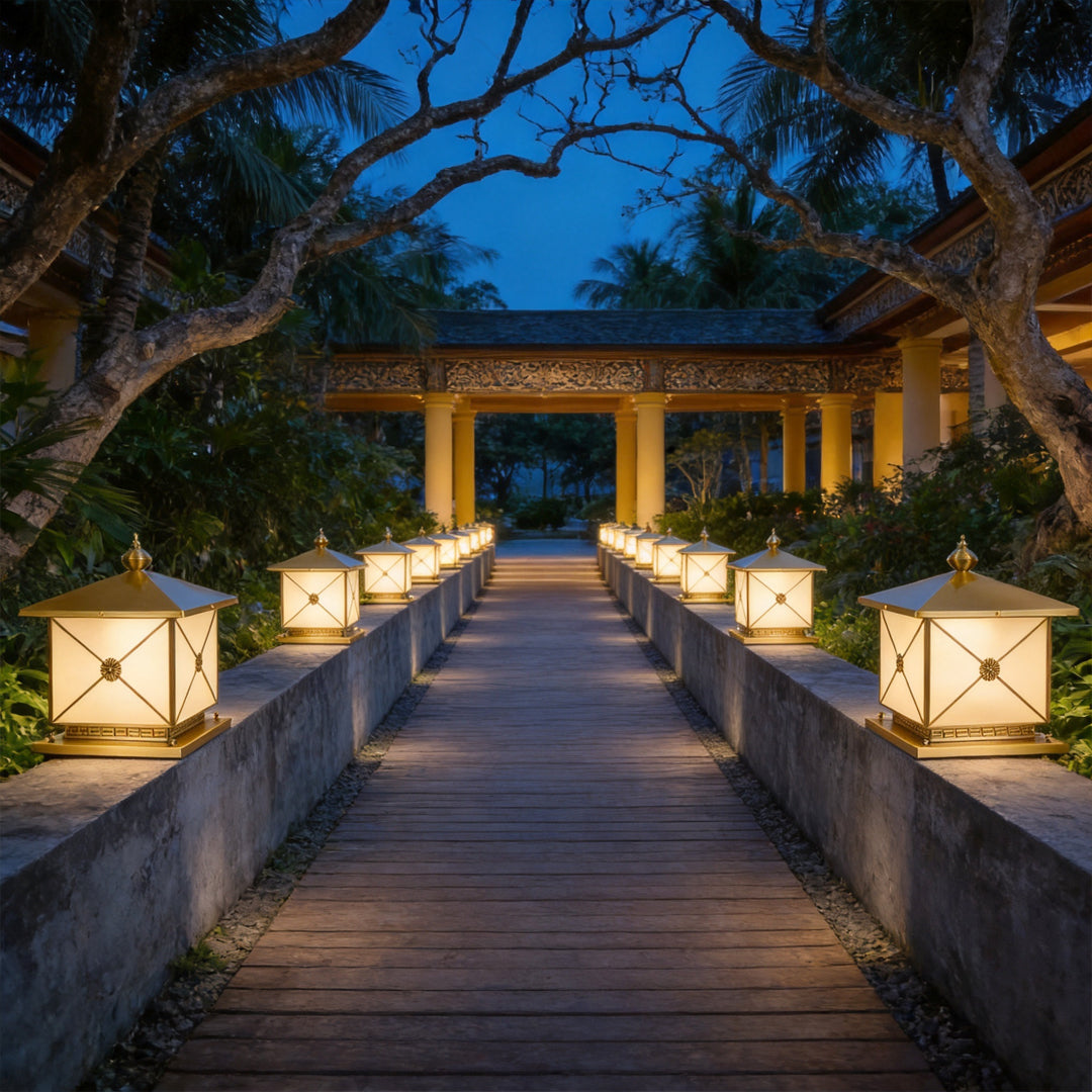 Warm pillar light solar fixtures illuminating a modern outdoor bridge walkway at night.