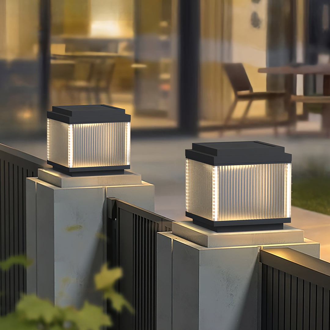 Pillar lighting outdoor fixtures installed on modern stone columns, providing warm pathway illumination.