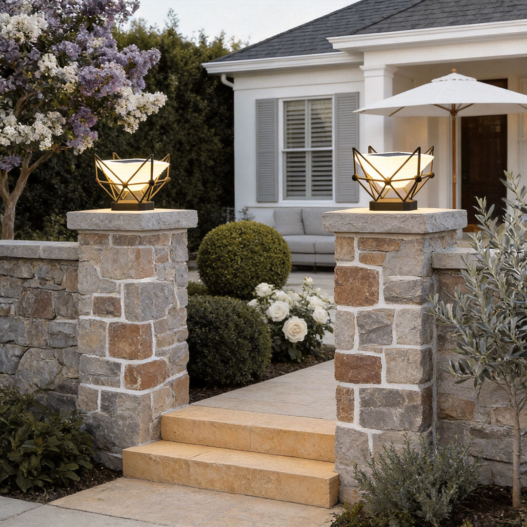 Elegant pillar lights for garden installed on stone pillars at the entrance of a residential home.