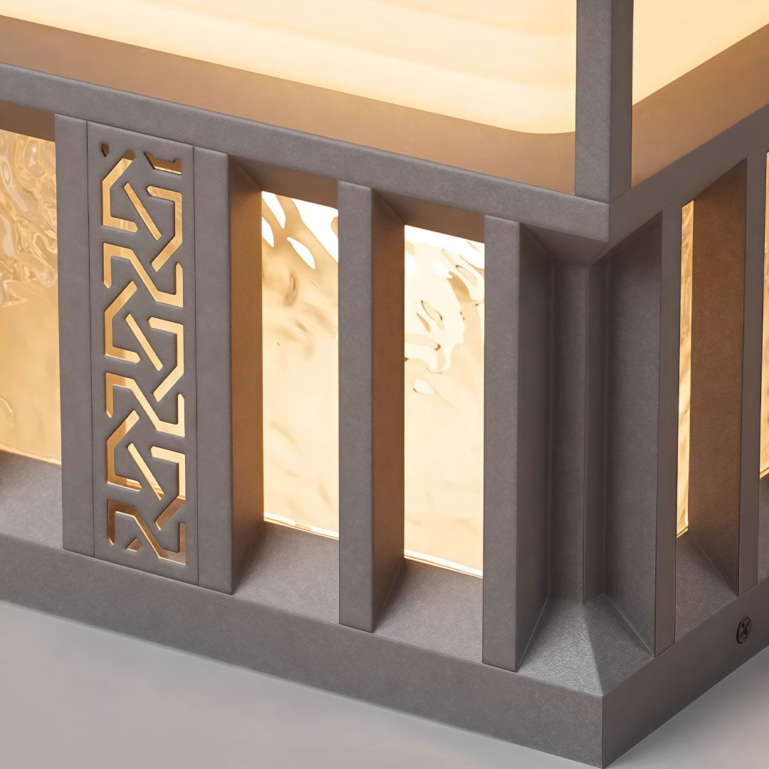 Pillar lights for house with a unique design, casting a warm glow on a stone wall.