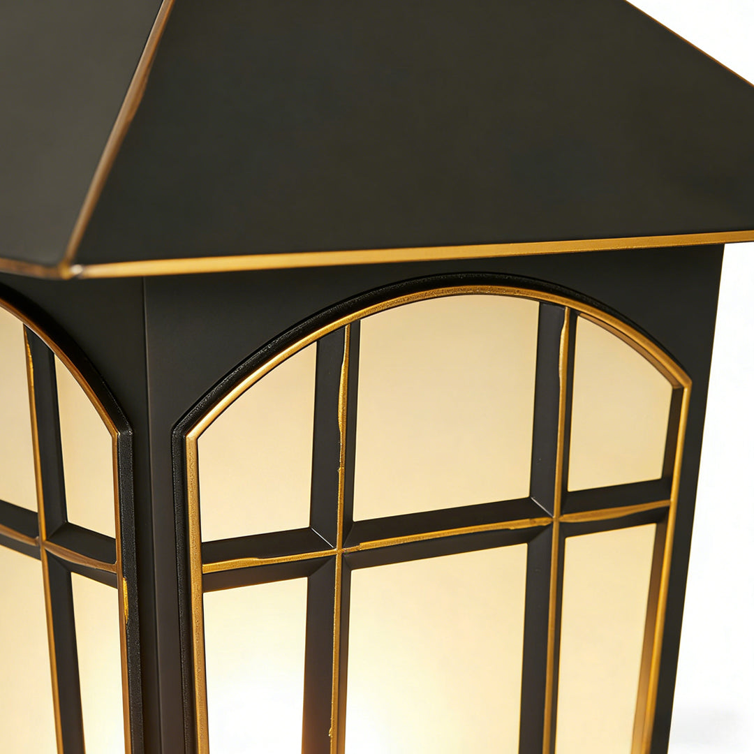 Close up detail of pillar lights outdoor modern design featuring a black metal frame with arched panels and warm internal glow.