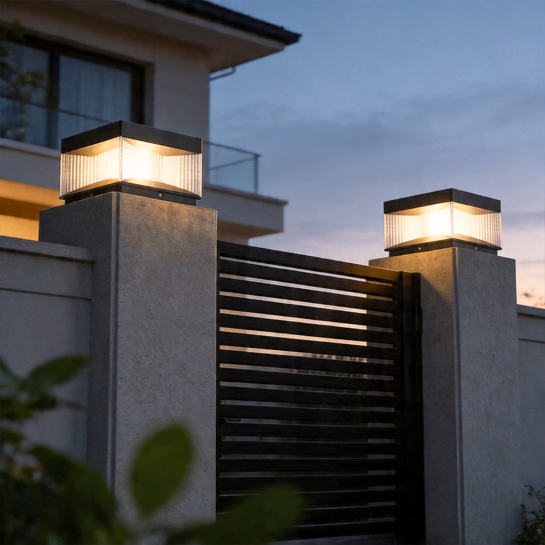 Pillar lights outdoor solar illuminating modern black gate pillars with warm LED glow at dusk.