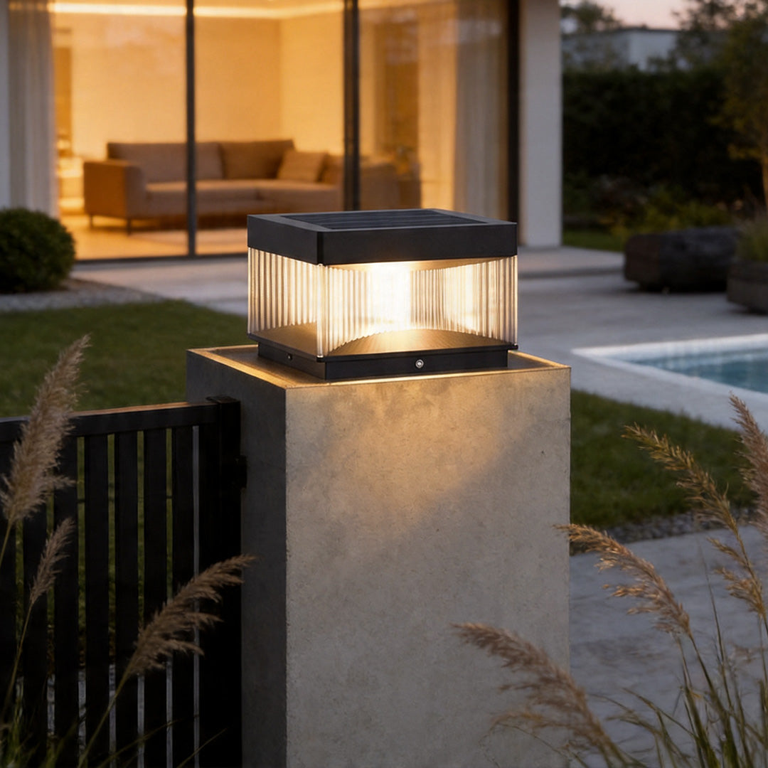 Pillar lights outdoor solar installed on modern concrete fence post with warm evening illumination.