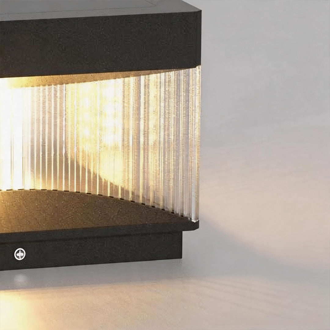 Close-up detail of pillar lights outdoor solar showing ribbed transparent diffuser and warm lighting.