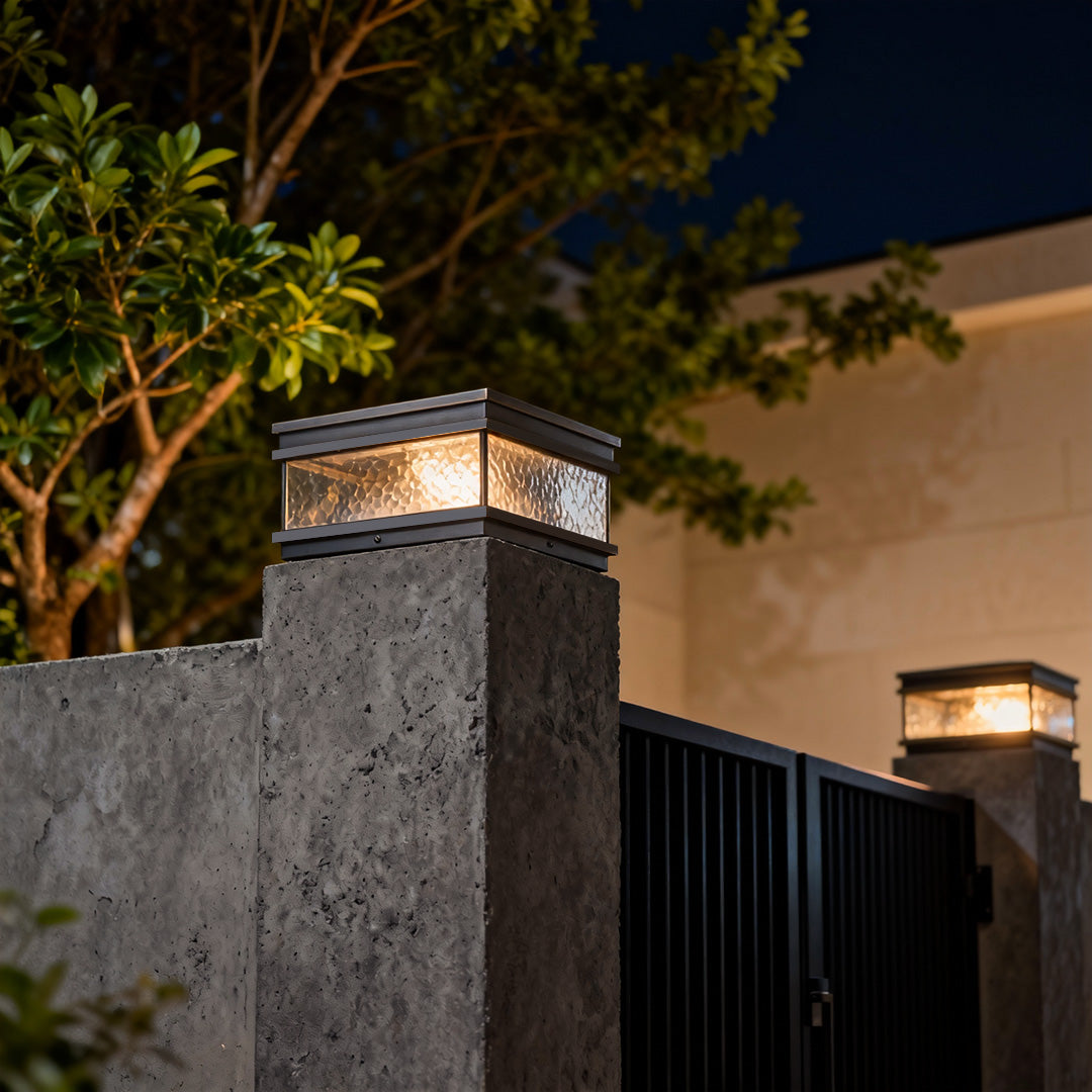 Pillar mount light mounted on a concrete fence post, enhancing outdoor security and decorative lighting after sunset.