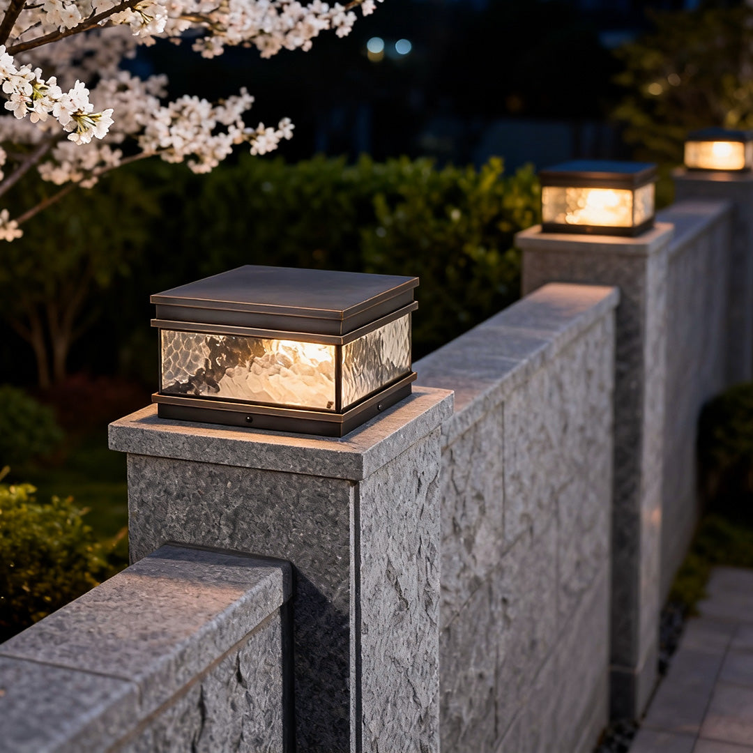 Pillar mount light installed on a stone wall pillar, providing warm ambient illumination for outdoor garden and entrance areas.