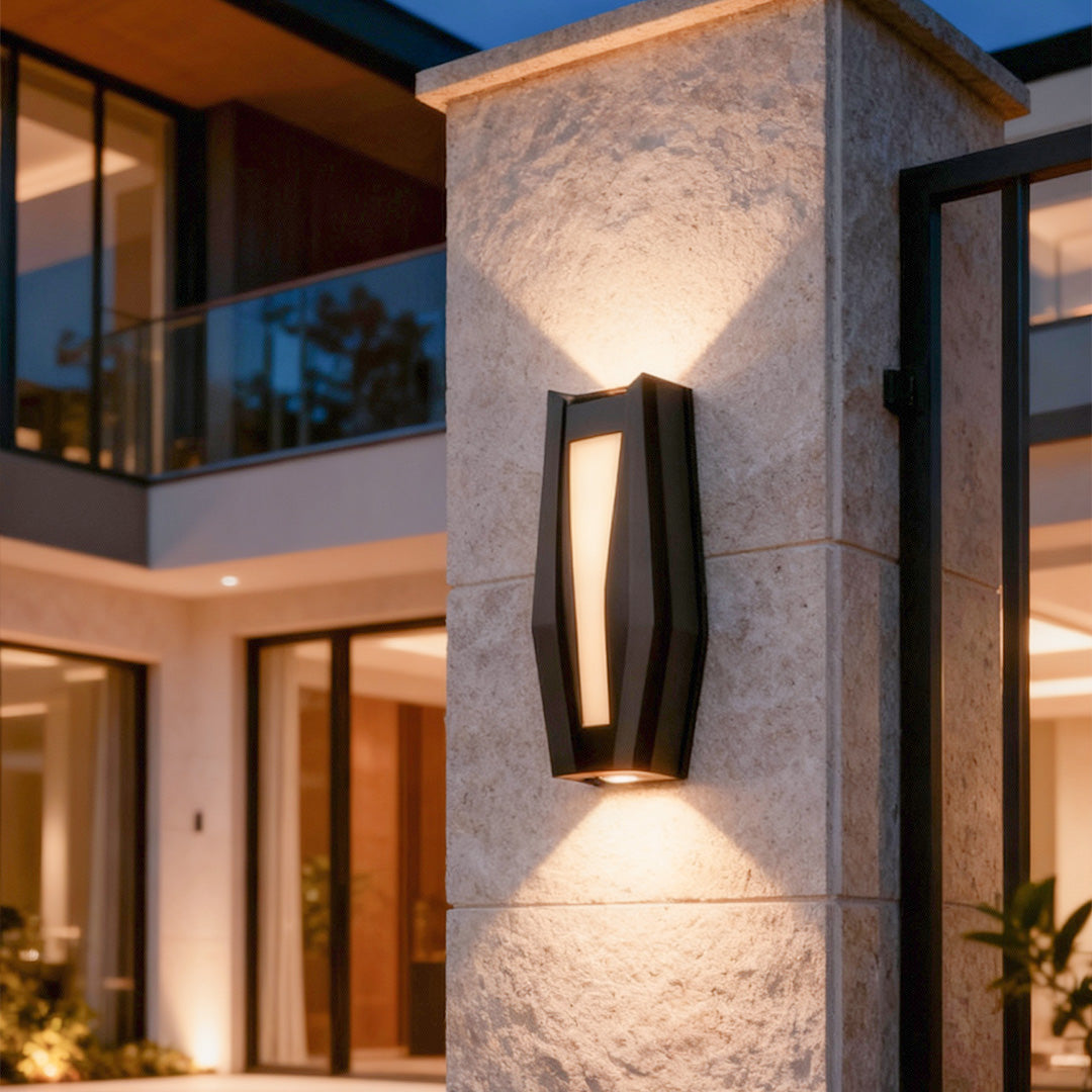 Up down outdoor wall light installed on a stone pillar, casting warm beams in a modern exterior space.