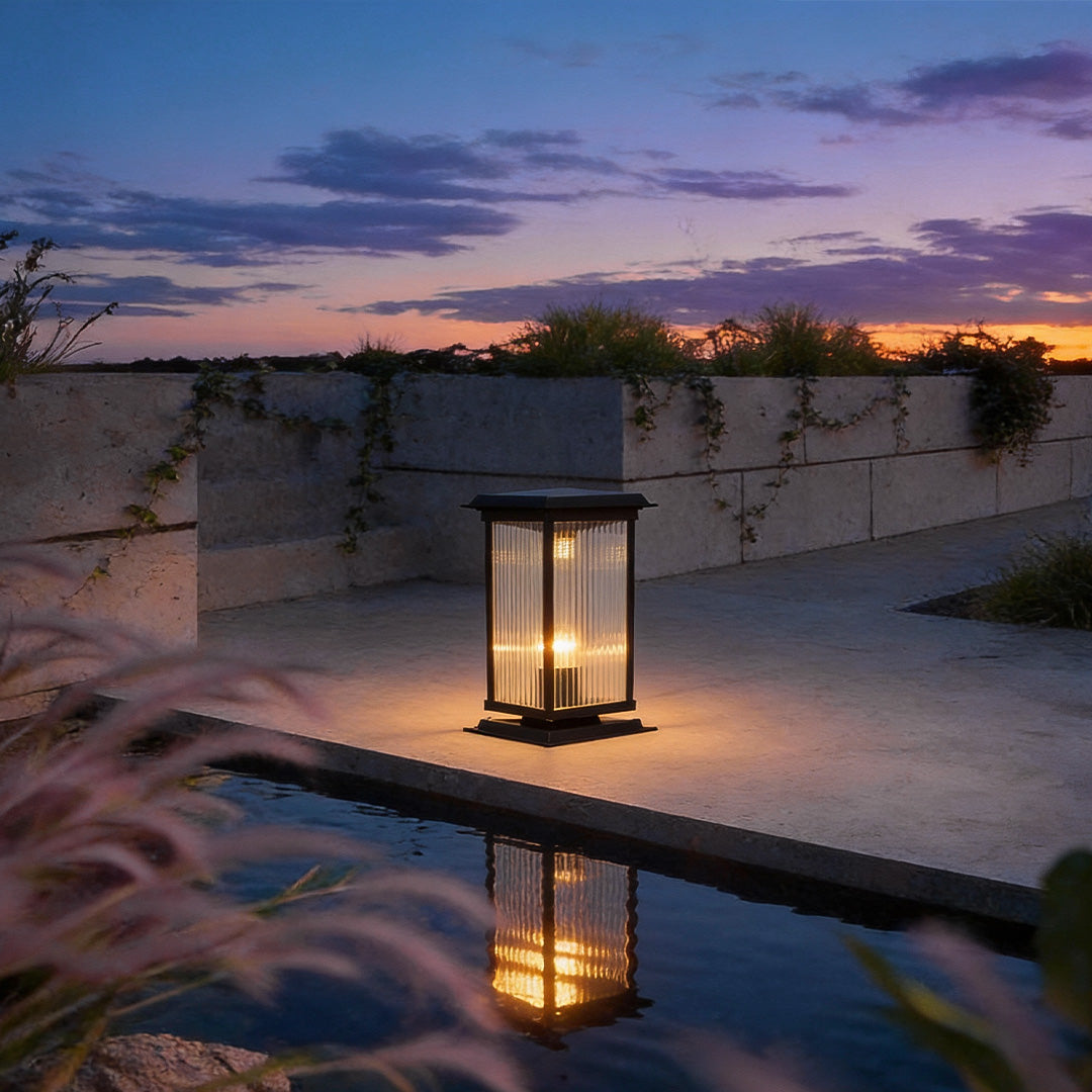 Pillar solar light placed beside a reflective water feature, creating elegant lighting and reflections in a minimalist courtyard.