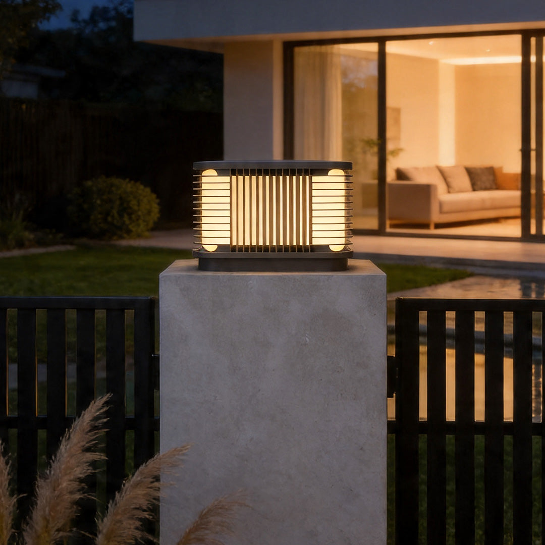 Pillar solar lights on concrete fence posts with modern layered lighting design beside luxury home.