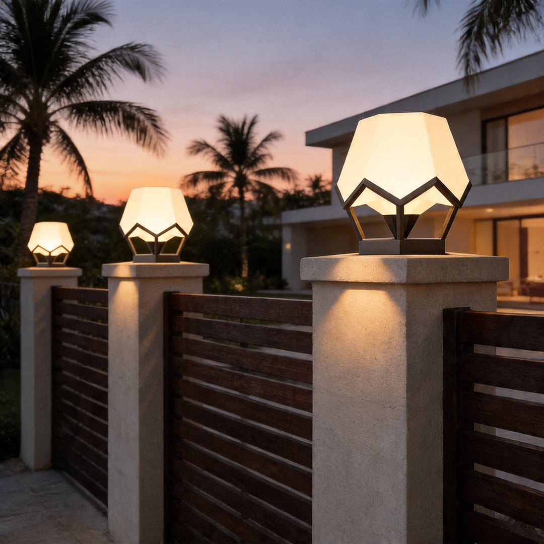Pillar top solar lights mounted on fence columns creating elegant tropical evening lighting design.