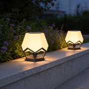 Pillar top solar lights installed on modern garden wall with warm decorative outdoor illumination.