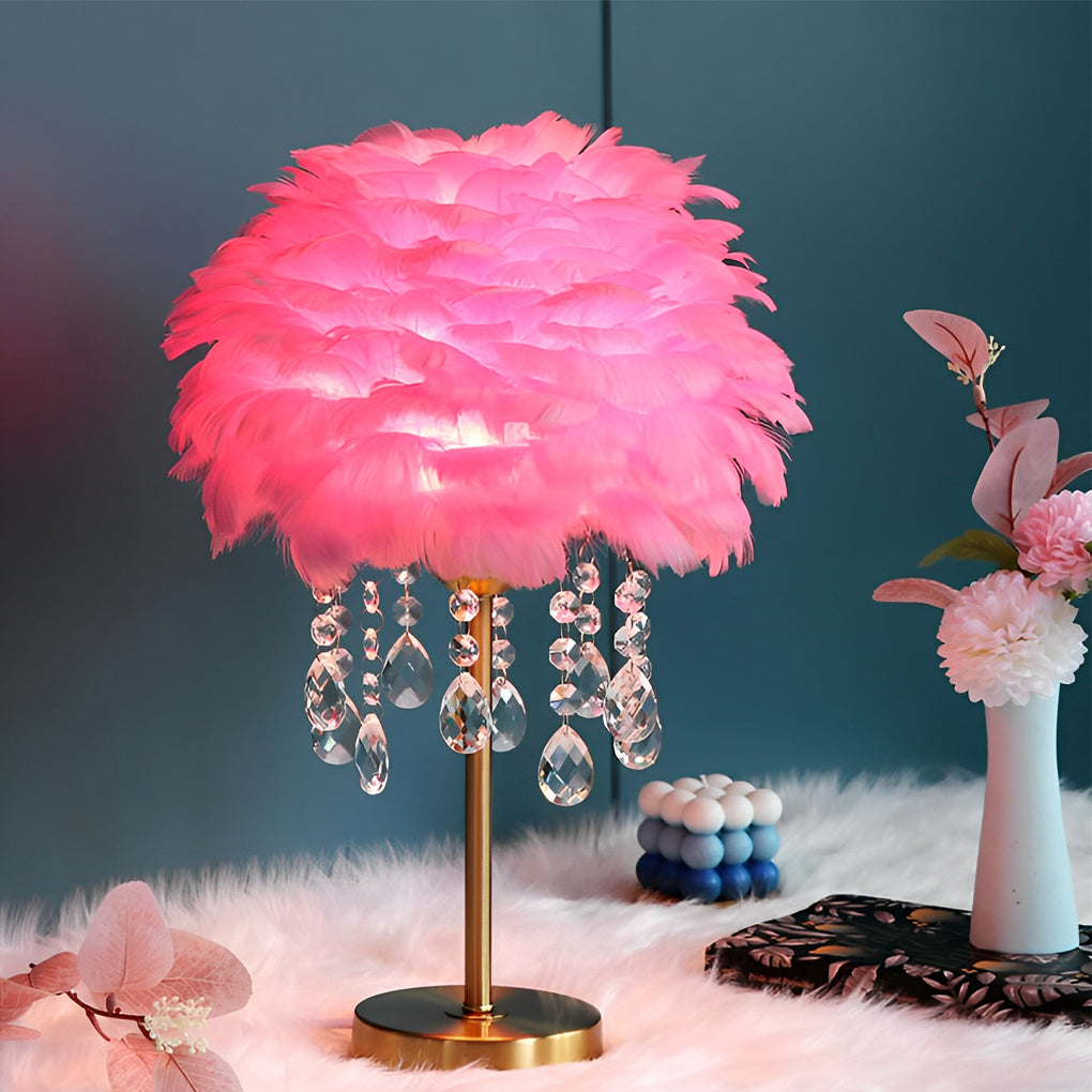 Pink feather table lamp with hanging crystal drops on a decorative table.