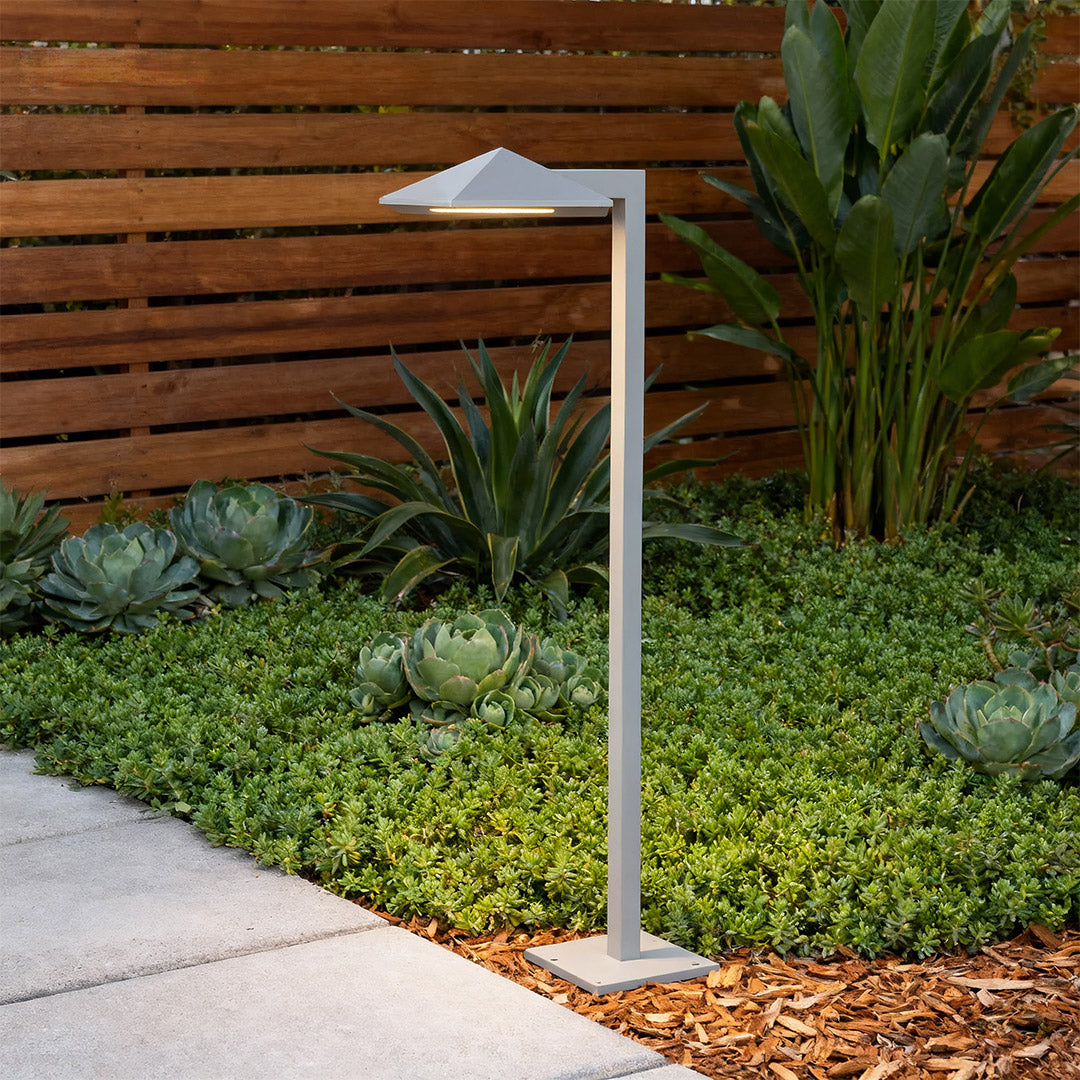 Plug-in pathway light along a paved walkway, offering stylish and functional lighting.