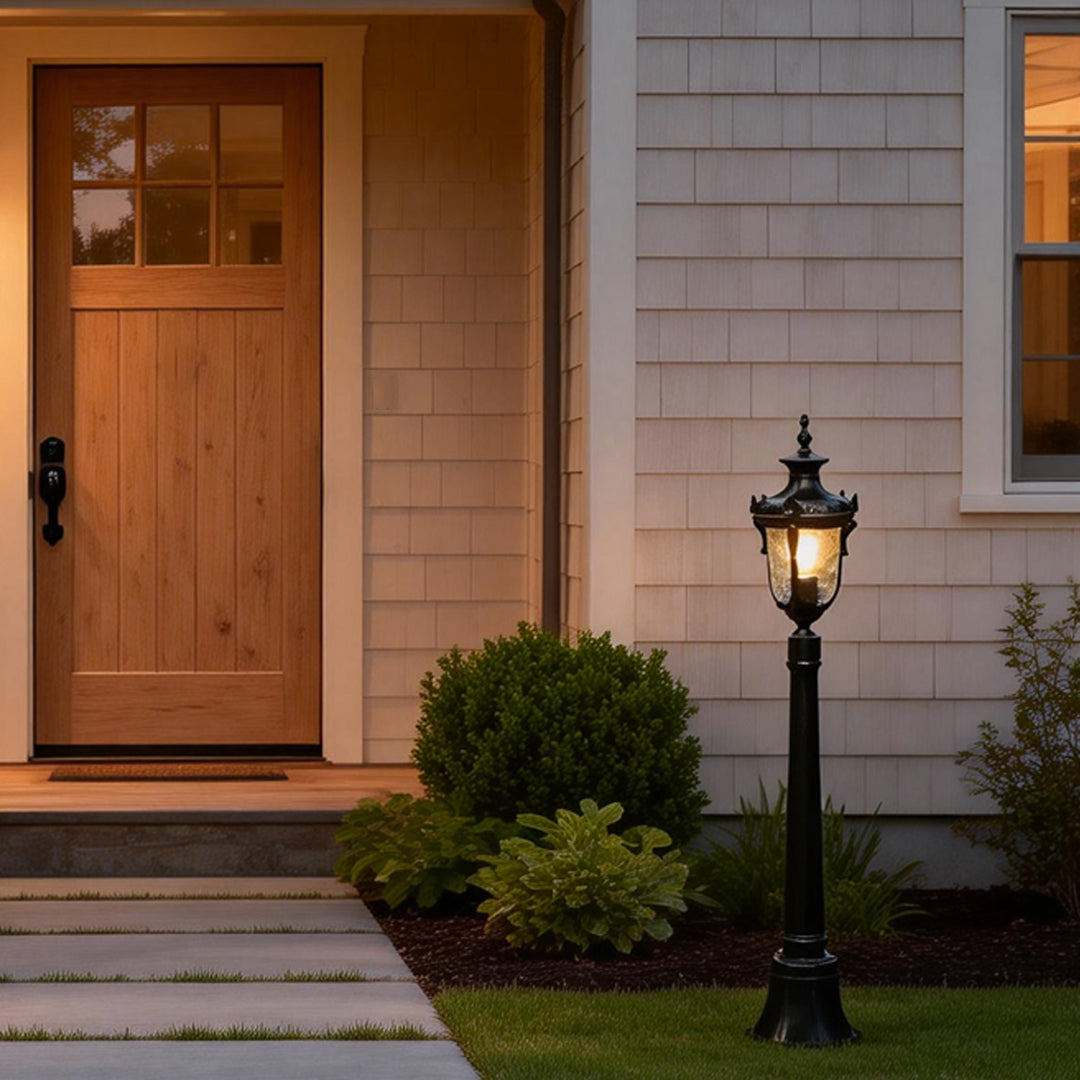Poles for yard lights illuminating a pathway near a wooden house entrance.