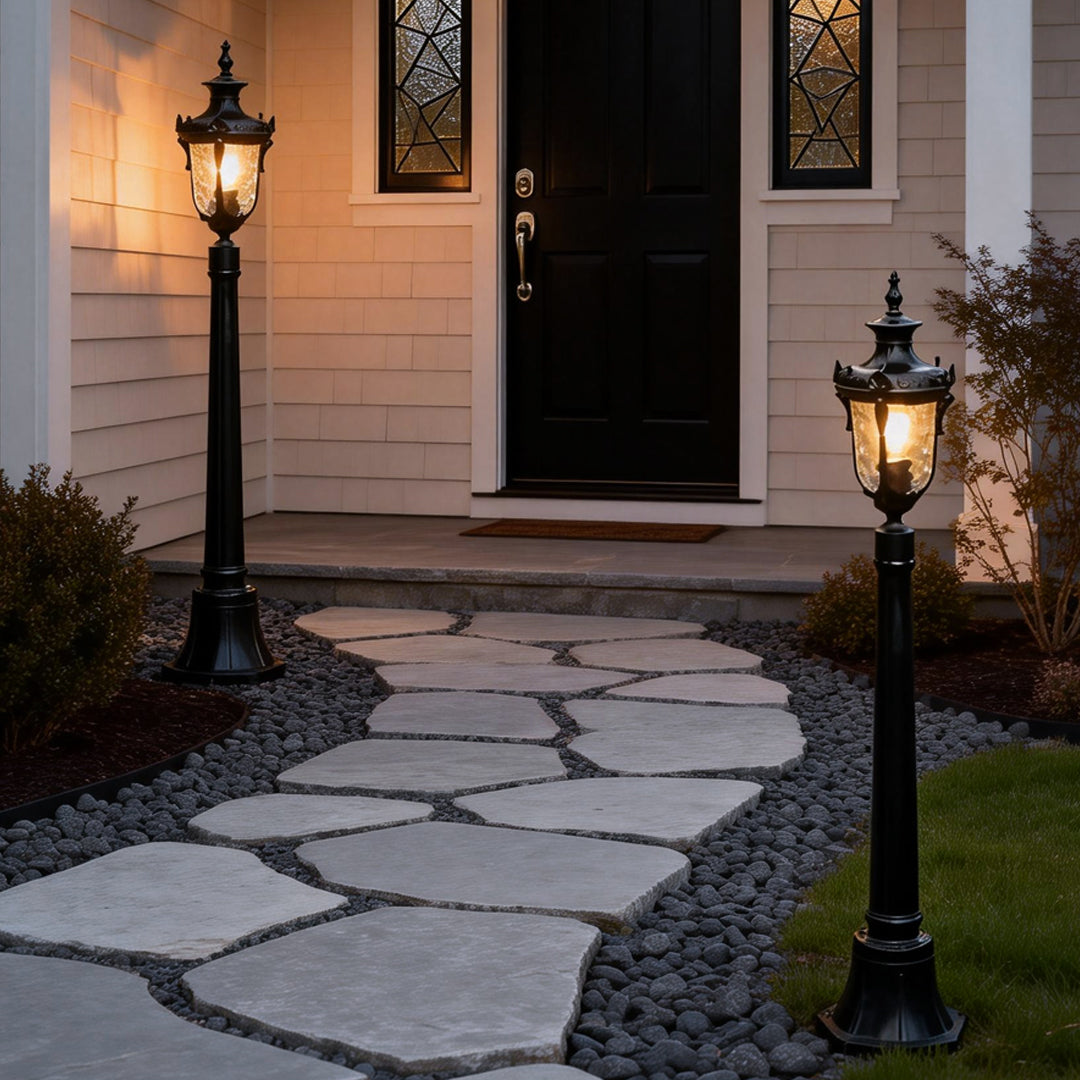 Poles for yard lights providing warm light along a stone walkway.