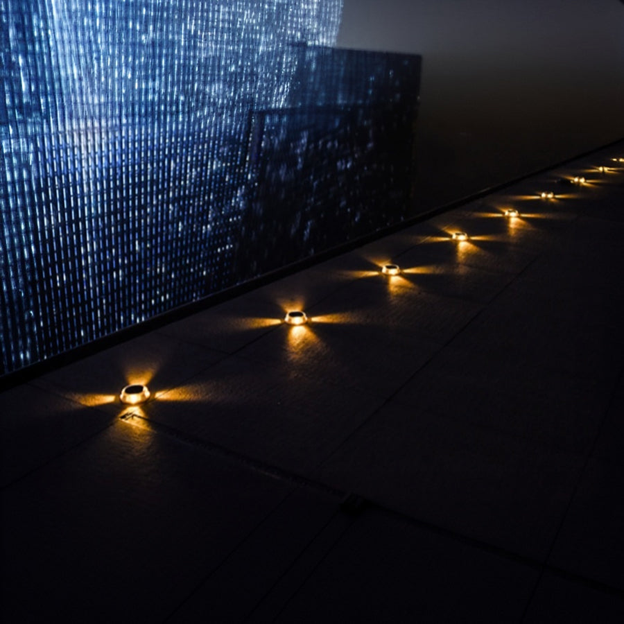 Blue tiled pool area featuring solar ground lights creating elegant underwater-style illumination effect