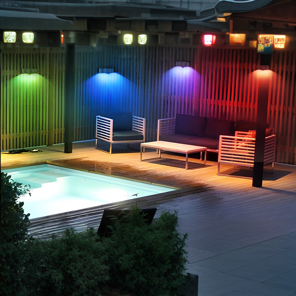 Contemporary poolside area featuring colorful RGB LED wall lights creating vibrant nighttime atmosphere
