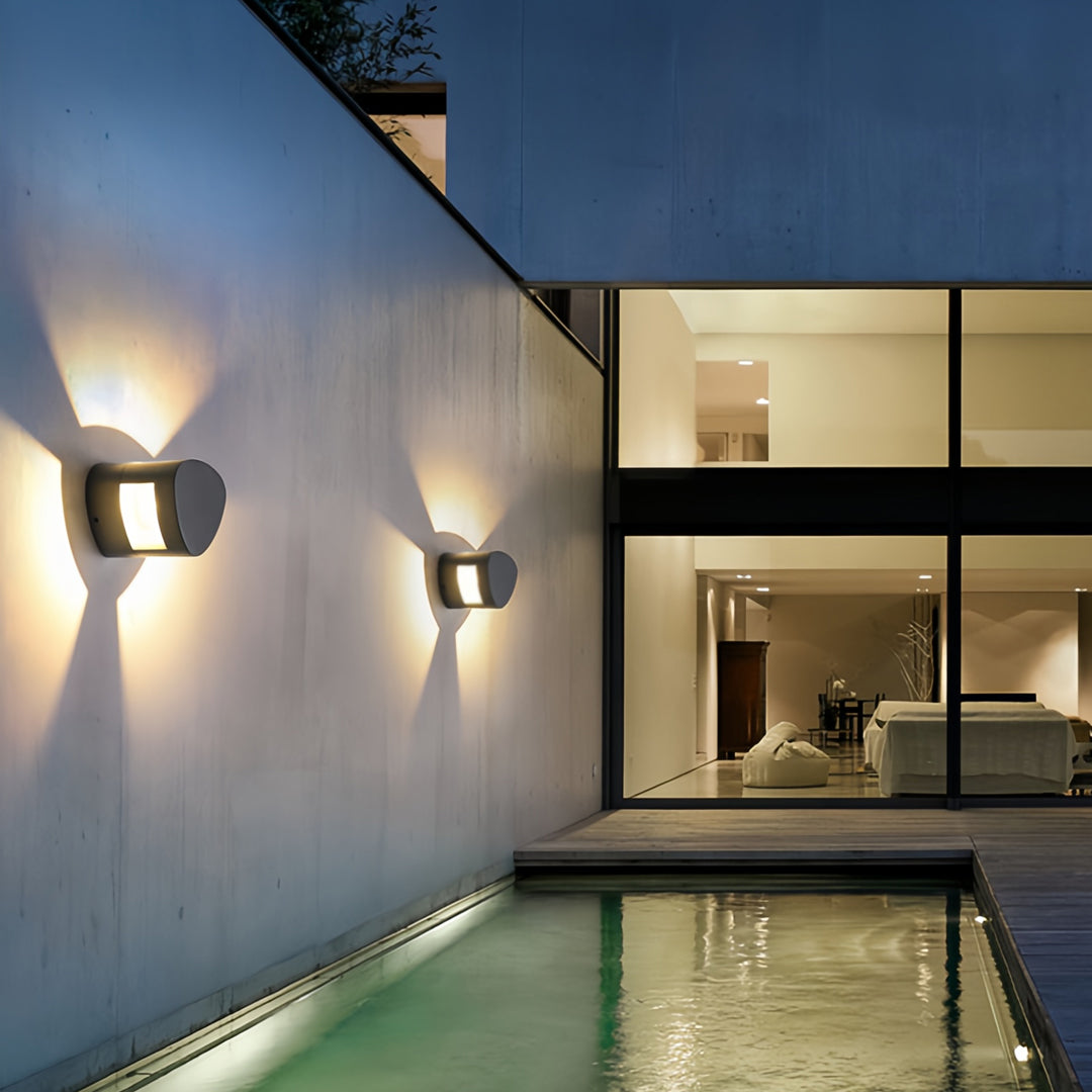 Modern wall light outdoor fixtures illuminating a poolside contemporary architectural facade.