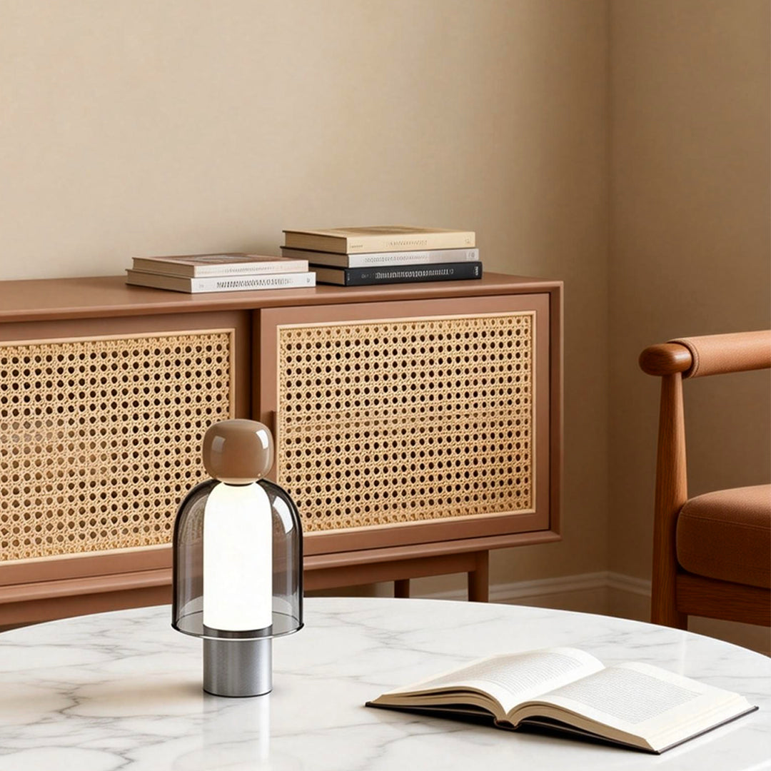 Portable glass table light providing soft light beside a modern cabinet.