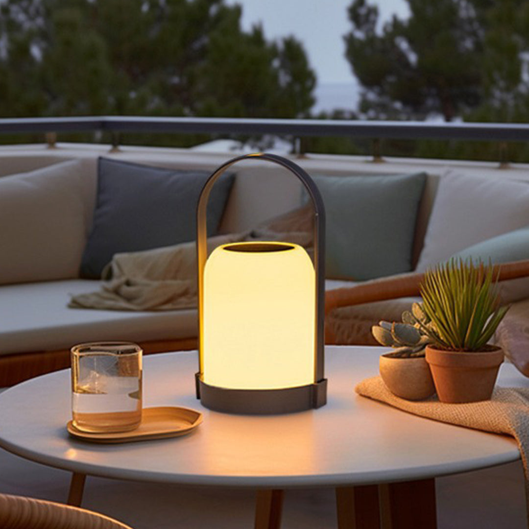 Contemporary portable lamp creating intimate lighting atmosphere on modern outdoor coffee table setup