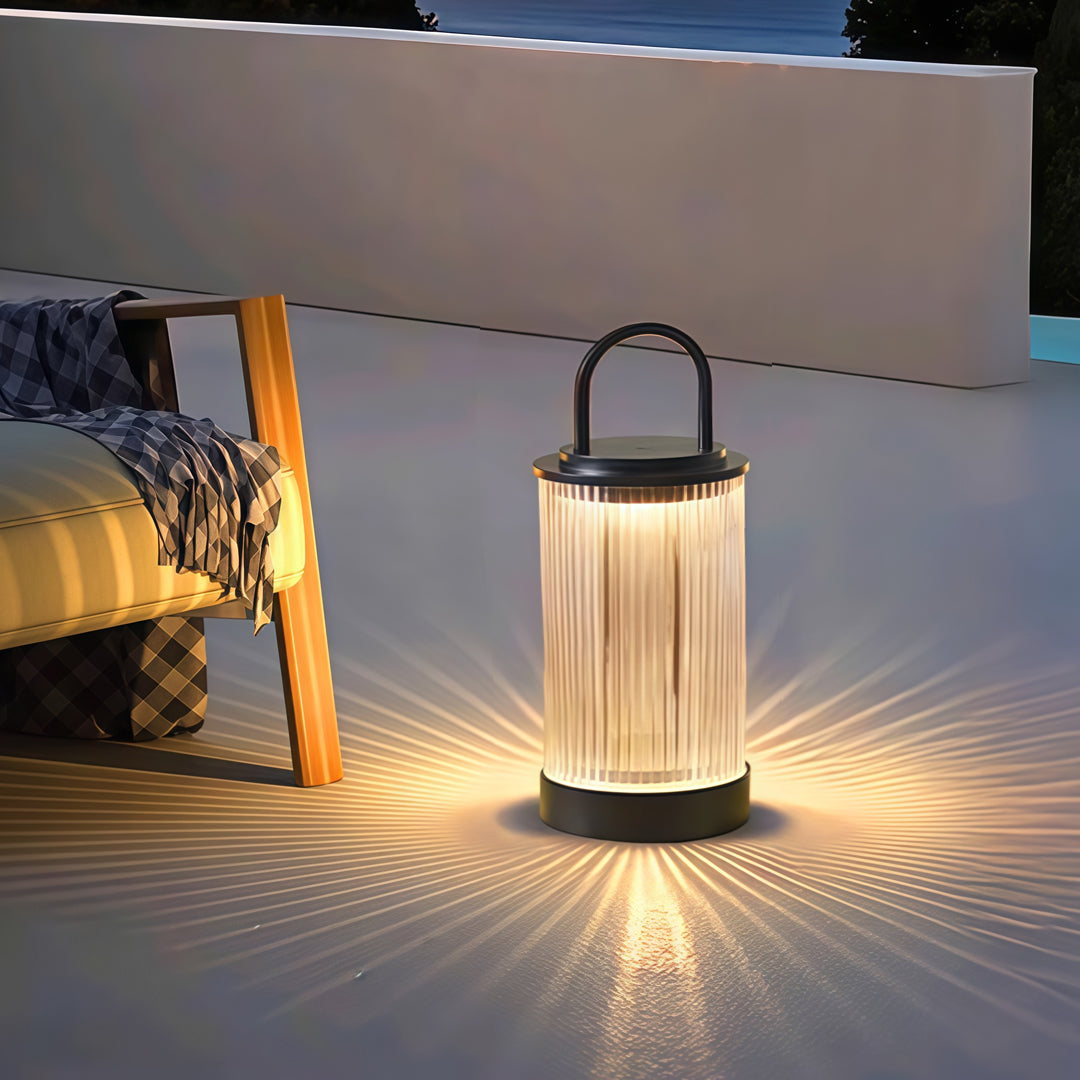 Portable lantern glowing warmly beside garden plants, creating a soft nighttime landscape effect.