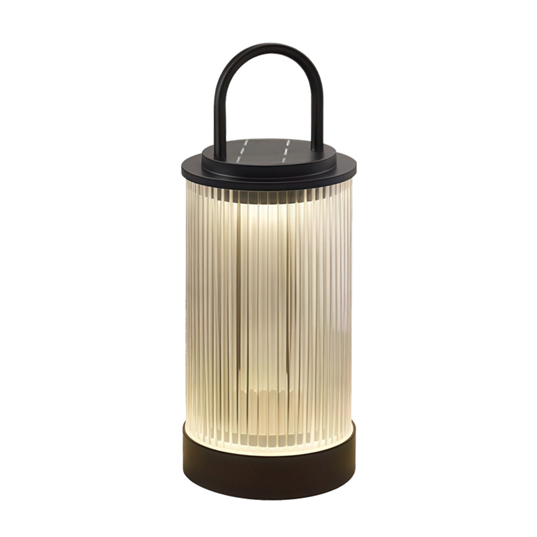 Portable lantern used for outdoor pathway lighting in landscaped yard during nighttime.