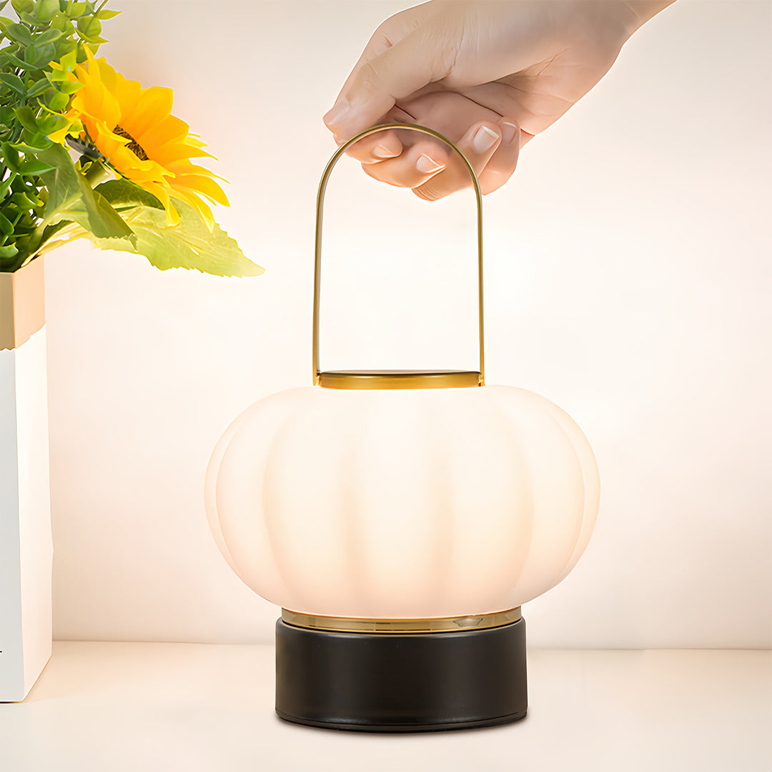Portable lantern table lamp with decorative fluted shade creating warm ambient lighting