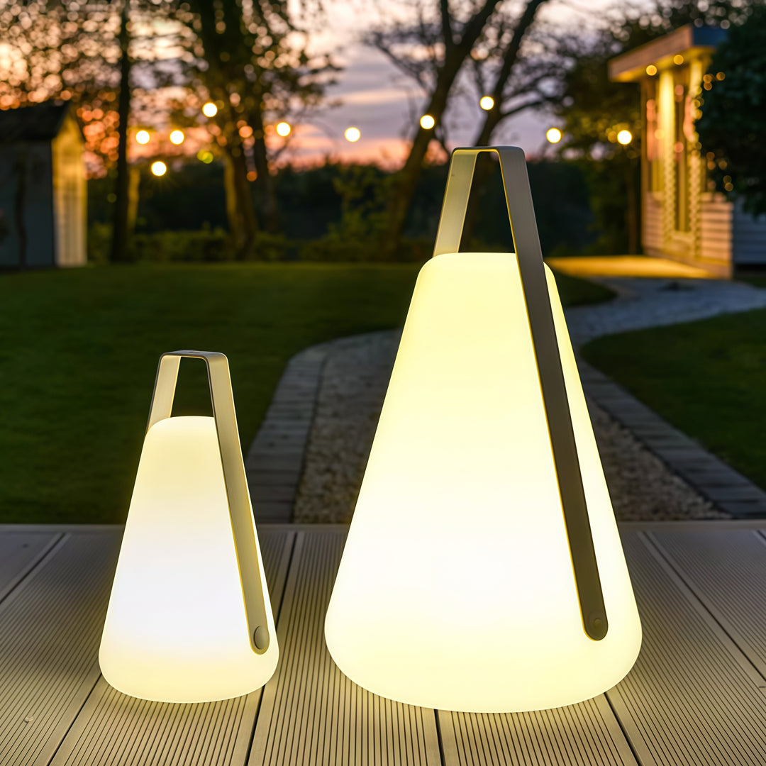Two portable led lanterns of different sizes arranged on a pathway at sunset, providing warm and decorative portable lighting.