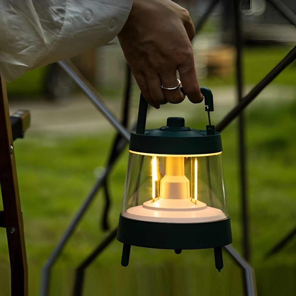 Portable rechargeable LED lamp with a black finish, providing ambient light in a garden.
