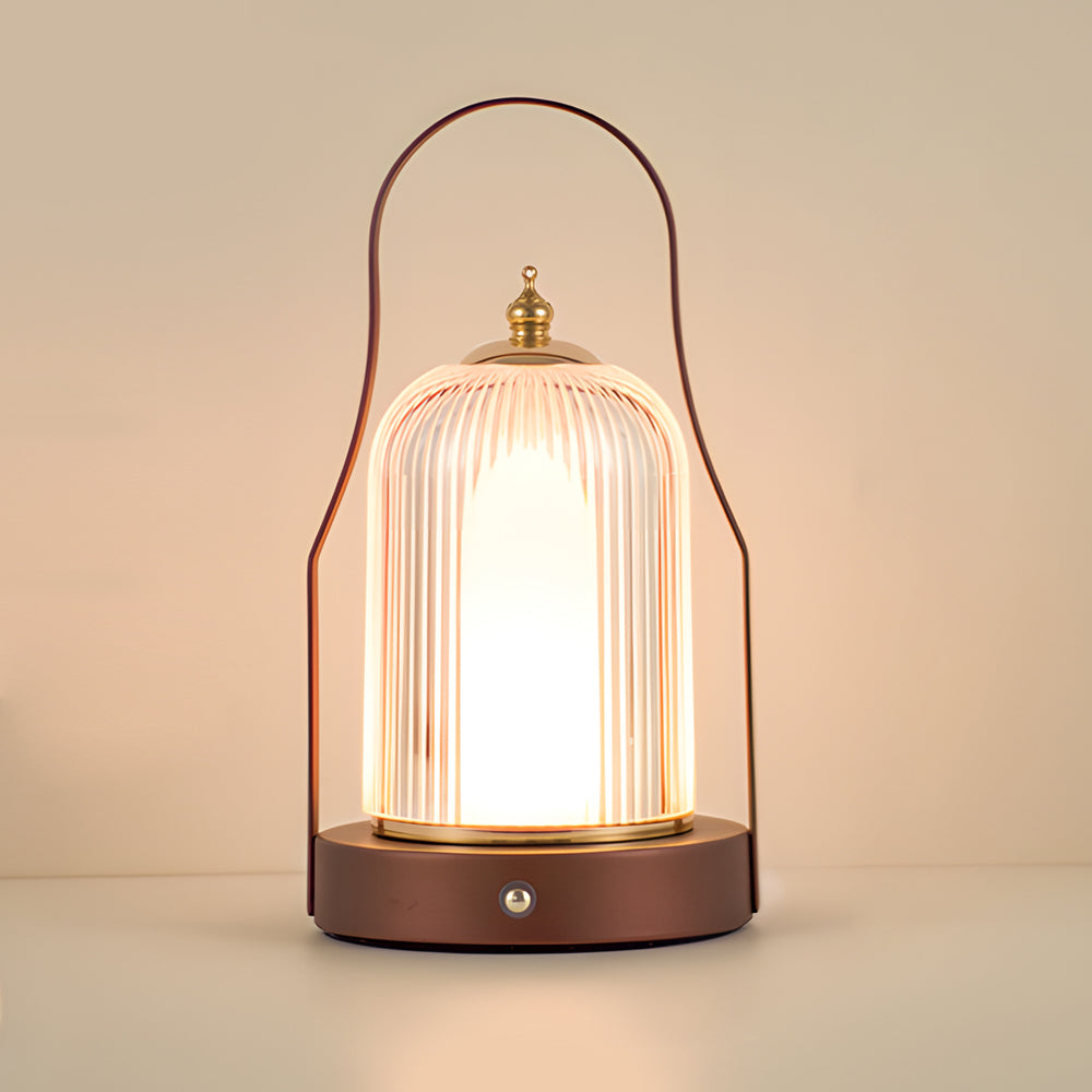 Portable rechargeable LED lantern illuminating a bedside table with warm light.