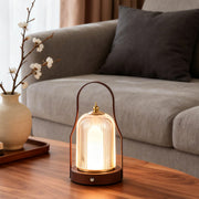 Portable rechargeable LED lantern illuminating a cozy living room with warm, ambient glow.