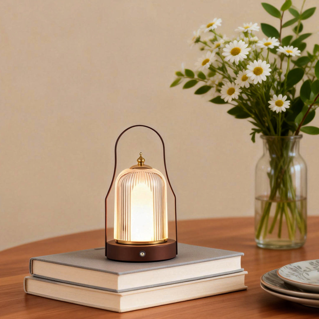 Portable rechargeable LED lantern providing soft light beside a vase of flowers.