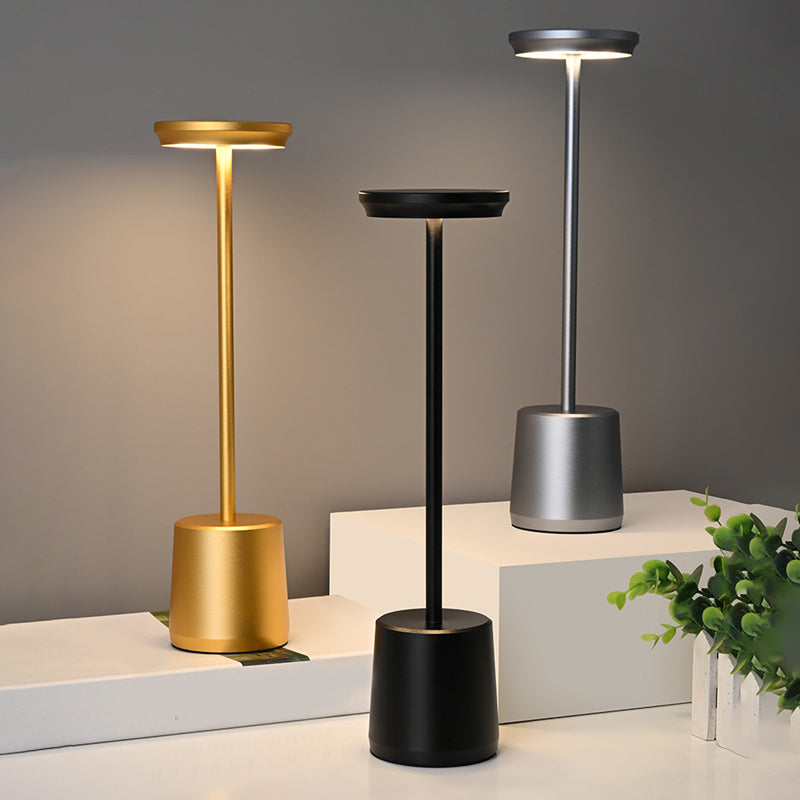Portable rechargeable LED table lamp enhancing a minimalist desk setup with elegant light.
