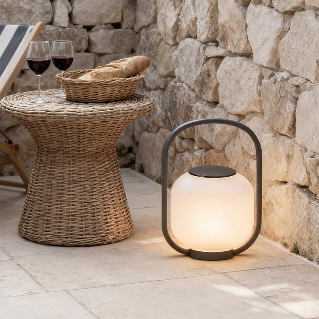 Portable solar lantern placed on a stone table, creating a cozy ambiance for an outdoor dining setup.