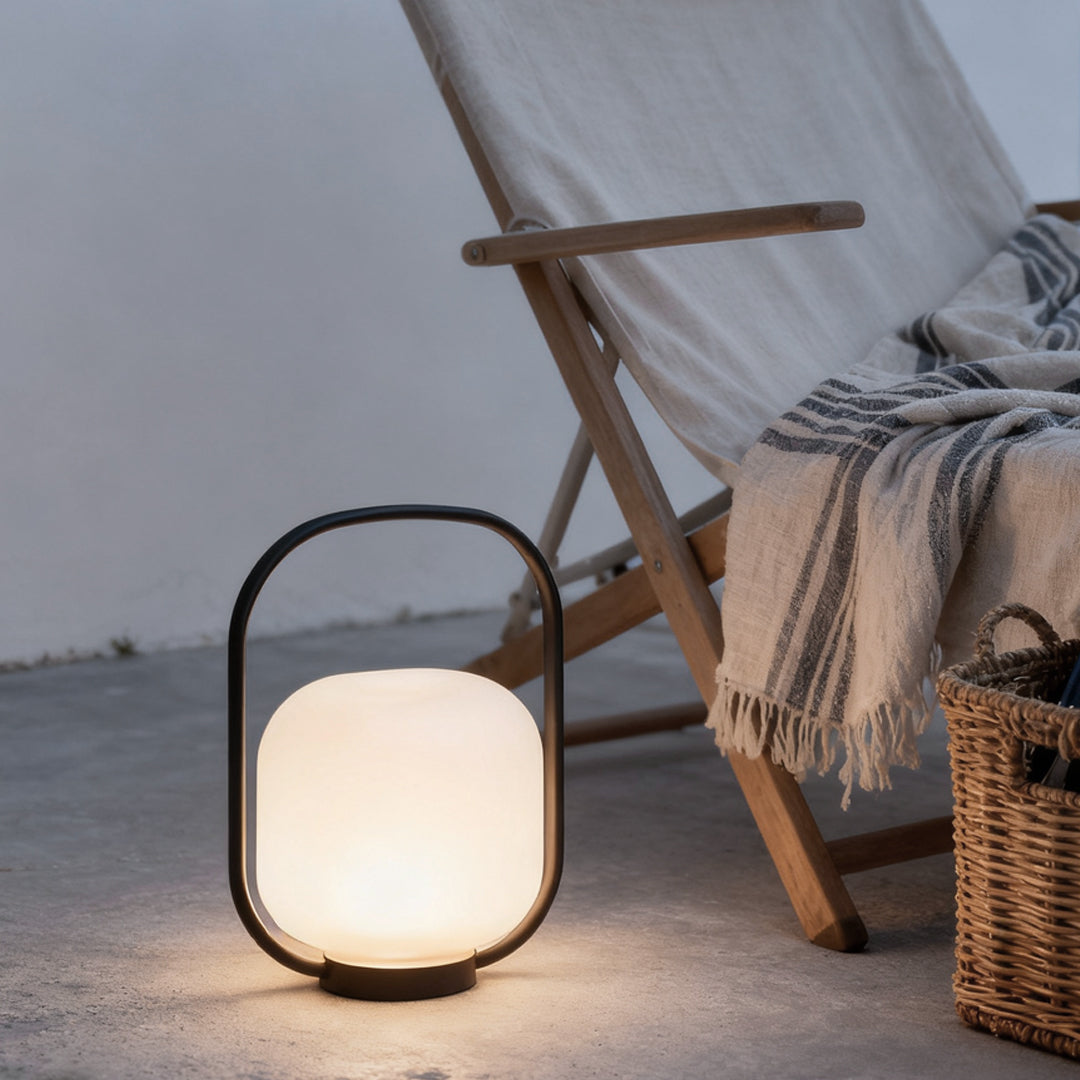 Portable solar lantern on a wooden deck chair, providing soft illumination for evening relaxation.