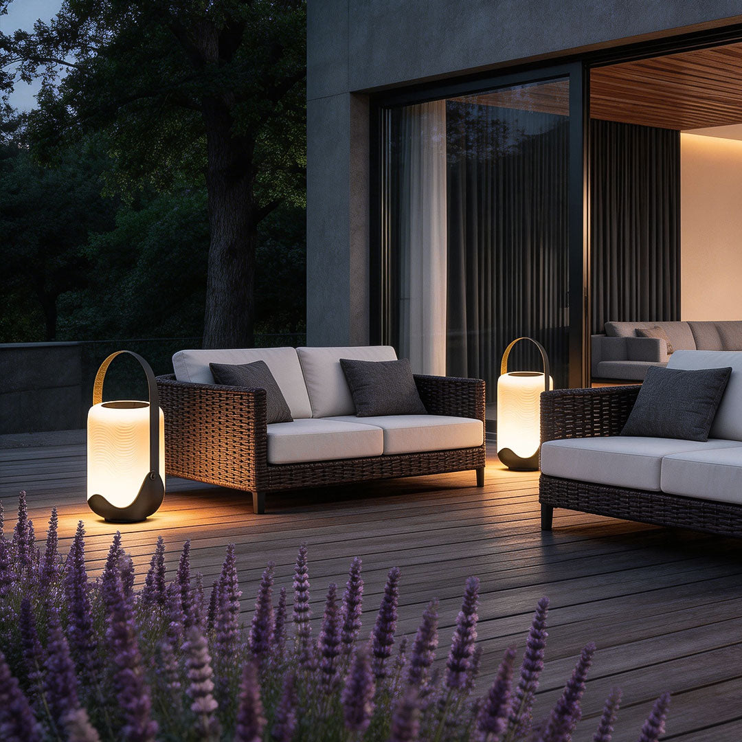 Portable solar lanterns with a warm glow, placed on a patio table.