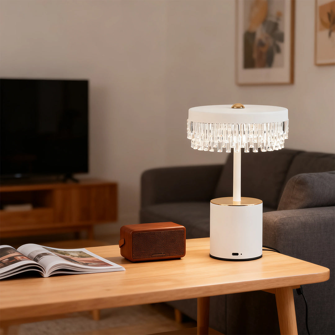 Portable white fringe table lamp on a coffee table next to a sofa, perfect for living room accent lighting.