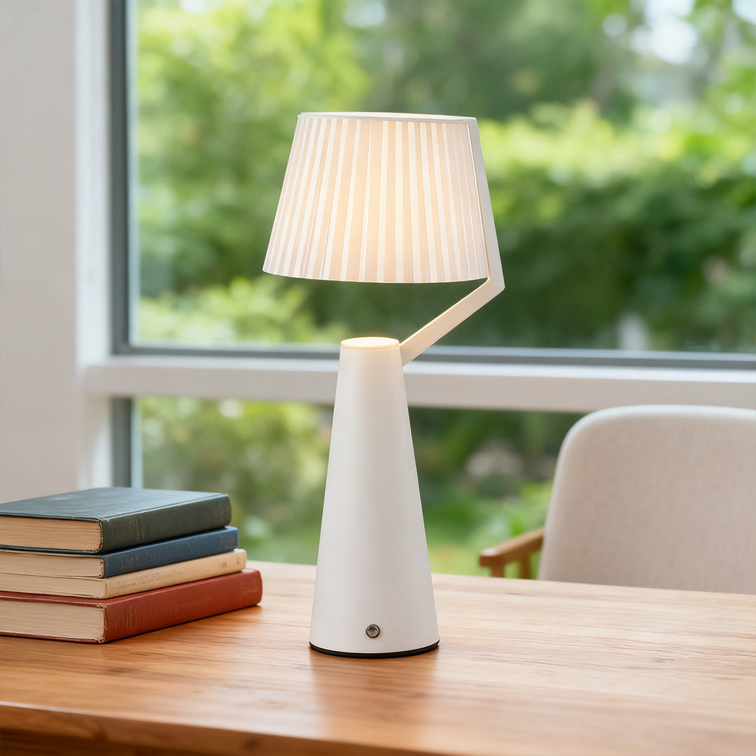 Portable white Nordic table lamp used as natural light desk decor in a bright home office setting.